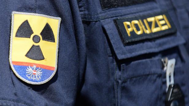 Auf der Uniform eines Polizisten befindet sich ein Aufnäher mit dem Warnzeichen für Radioaktivität.