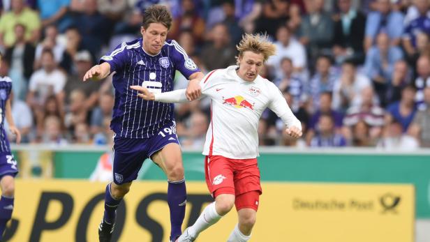 Zwei Fußballspieler kämpfen um den Ball während eines Spiels.