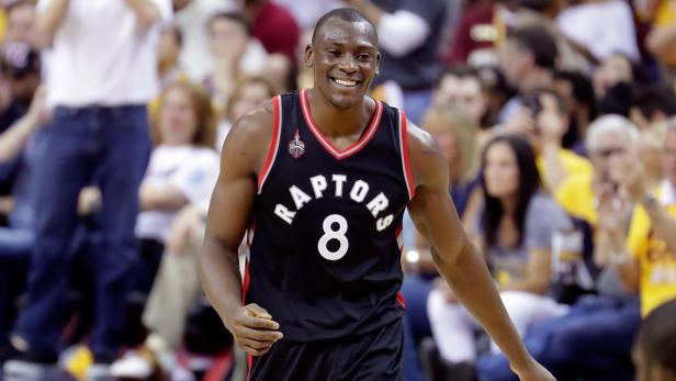 Basketballspieler Bismack Biyombo im Trikot der Toronto Raptors lächelt.