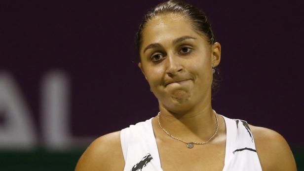 Eine Tennisspielerin blickt mit zusammengepressten Lippen drein.