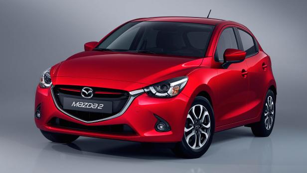 Ein roter Mazda 2 vor einem grauen Hintergrund.