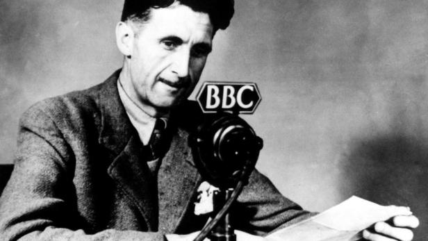 George Orwell liest an einem BBC-Mikrofon ein Manuskript.