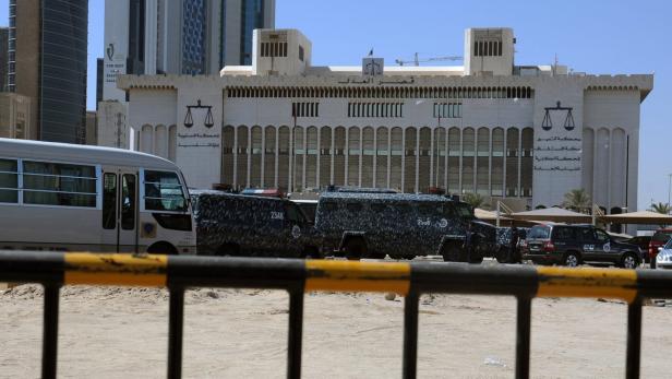 Vor dem Justizpalast in Kuwait stehen Militärfahrzeuge und ein Bus.
