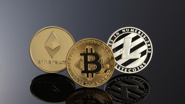 Close up shot of three main cryptocurrencies; bitcoin, ethereum and litecoin in dark surface.