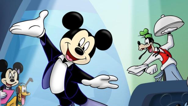 Micky Maus dirigiert, während Goofy mit einem Serviertablett herbeieilt; Minnie Maus und Pluto schauen zu.