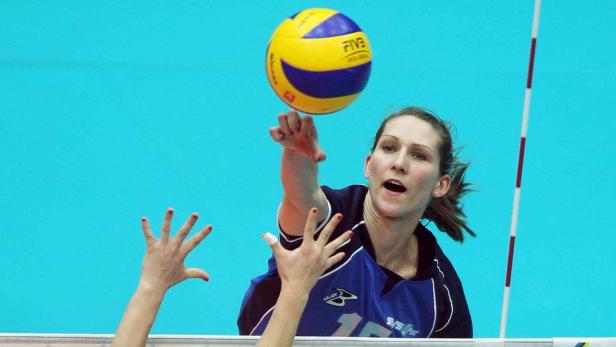 Eine Volleyballspielerin schlägt einen gelb-blauen Volleyball.