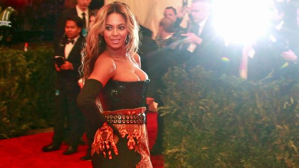Beyoncé auf dem roten Teppich in einem trägerlosen Kleid mit dunklem Oberteil und gemustertem Rock.