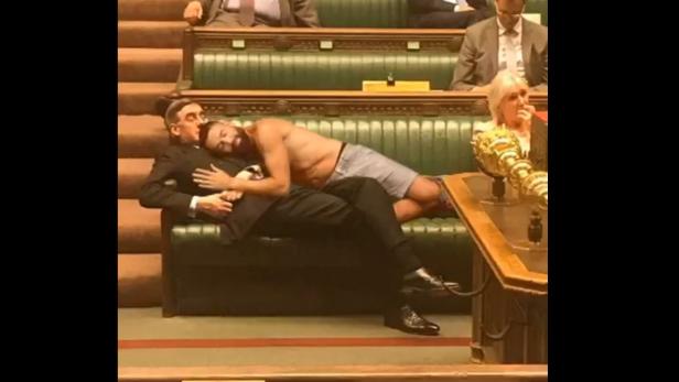 Ein Mann schläft scheinbar auf dem britischen Politiker Jacob Rees-Mogg, tatsächlich handelt es sich aber um eine Fälschung