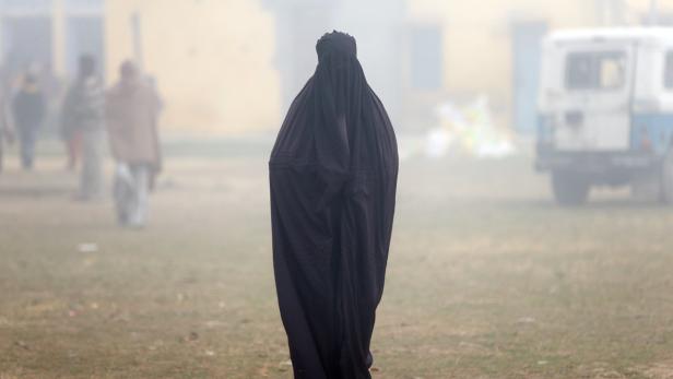 A woman wearing a burka leaves a polling booth after voting during the state assembly election, in the town of Deoband, in the state of Uttar Pradesh