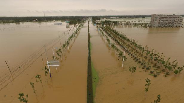 Rescuers take a boat to check around at a flooded .