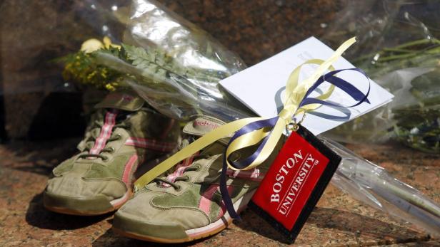 A pair of running shoes is seen at a makeshift memorial on Boston University&#039;s campus in memory of the Boston University Graduate student who was killed in the explosions at the Boston Marathon in Boston, Massachusetts April 17, 2013. REUTERS/Jessica Rinaldi (UNITED STATES - Tags: CRIME LAW SPORT ATHLETICS OBITUARY)