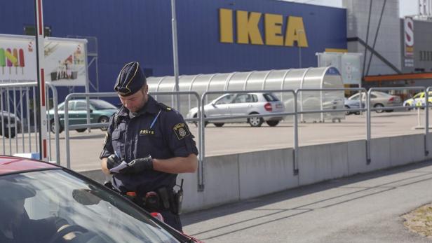 Ein Polizist schreibt einen Strafzettel vor einem IKEA-Gebäude.