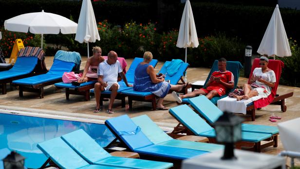 Thomas Cook holiday makers chat by a swimming pool in their hotel in Fethiye