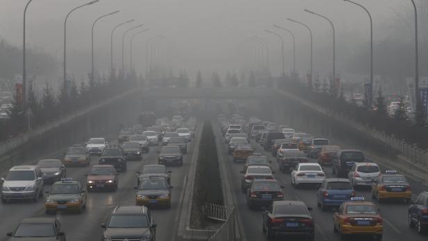 Starker Smog beeinträchtigt den Verkehr auf einer mehrspurigen Straße.