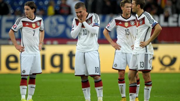 Vier deutsche Fußballspieler stehen während eines Spiels auf dem Rasen.