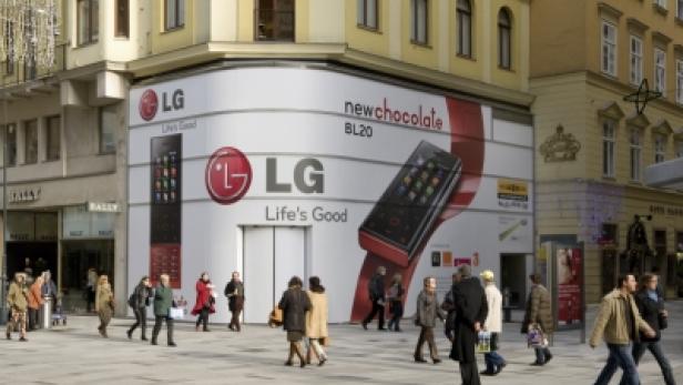 Ein großes LG-Werbeplakat für das „New Chocolate BL20“-Handy an einer Gebäudeecke in einer belebten Stadt.