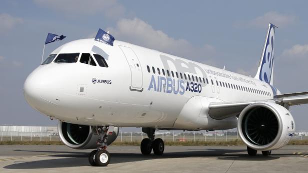 Ein weißer Airbus A320 steht auf einem Rollfeld.