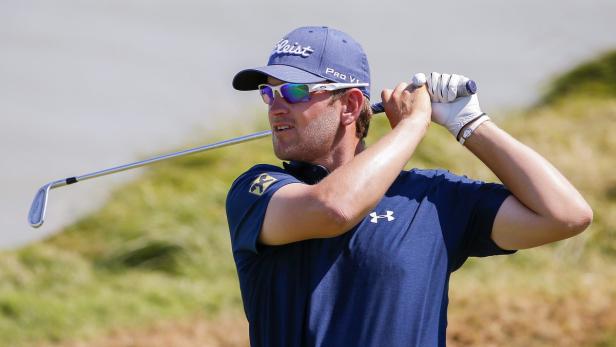 Ein Golfspieler schwingt seinen Schläger auf einem Golfplatz.
