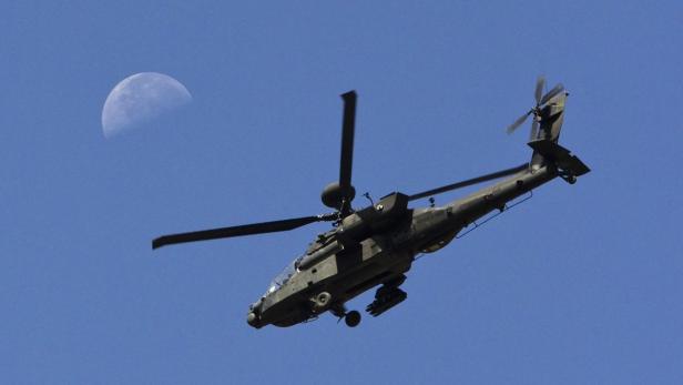 A U.S. Army Apache flies past the moon in the Zharay district of Kandahar province, southern Afghanistan in this file photo from June 11, 2012. Production of new Chinook and Apache helicopters, both made by Boeing, will be slowed or halted, said the Department of Defense, if automatic government cuts go into effect March 1, 2013 due to sequestration. REUTERS/Shamil Zhumatov/Files (AFGHANISTAN - Tags: MILITARY CIVIL UNREST CONFLICT)