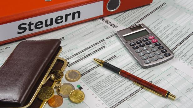 tax form and ring binder with print tax on it - in German language: Steuern