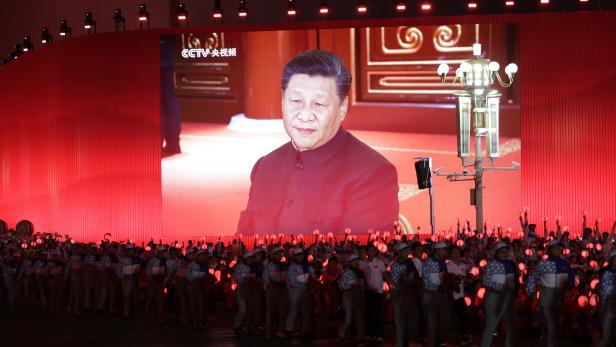 Chinese President Xi Jinping is seen on a giant screen as performers take part in the evening gala marking the 70th founding anniversary of People's Republic of China
