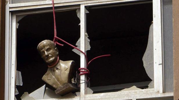 A bust of late Syrian President Hafez al-Assad, father of the current president Bashar al-Assad, is seen hung at a broken window of a building in Deir al-Zor April 2, 2013. Picture taken April 2, 2013. REUTERS/ Khalil Ashawi (SYRIA - Tags: CONFLICT TPX IMAGES OF THE DAY SOCIETY)