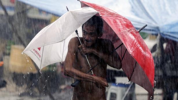 Ein Philippiner versucht sich vor den heftigen Regenfällen, ausgelöst durch El Niño, zu schützen