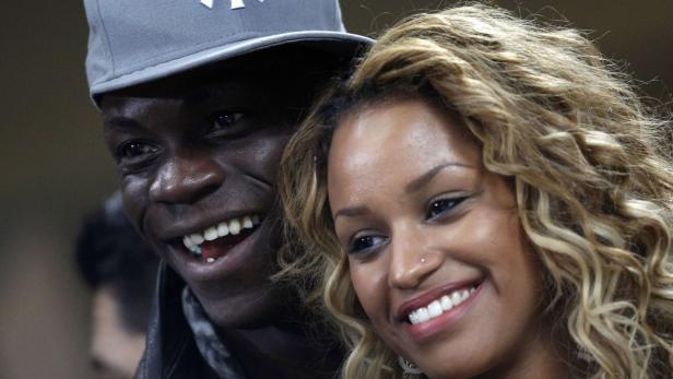 AC Milan&#039;s Mario Balotelli smiles next to his girlfriend, model Fanny Robert Neguesha, as they watch their Champions League soccer match against Barcelona at the San Siro stadium in Milan February 20, 2013. REUTERS/Tony Gentile (ITALY - Tags: SPORT SOCCER)