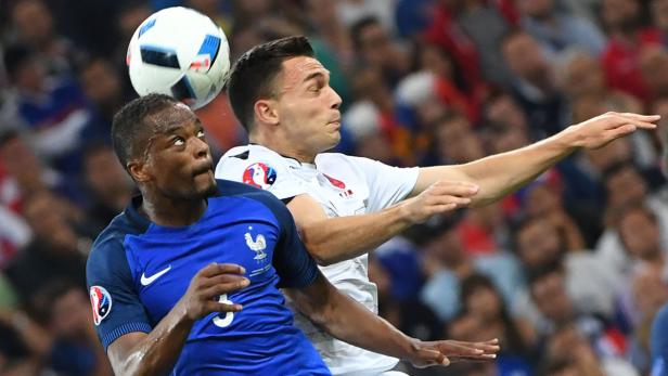 France&#039;s defender Patrice Evra (L) vies for the ball with Albania&#039;s midfielder Taulant Xhaka during the Euro 2016 group A football match between France and Albania at the Velodrome stadium in Marseille on June 15, 2016. / AFP PHOTO / BORIS HORVAT