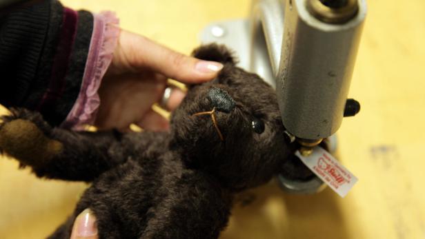 Ein Steiff-Teddybär wird mit einer Maschine bearbeitet, möglicherweise zur Reparatur oder Anpassung.
