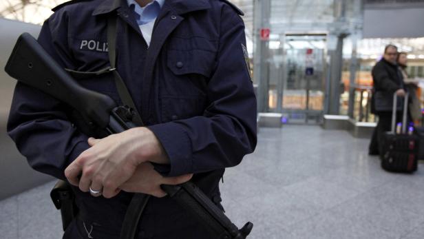 Ein Polizist mit Gewehr im Anschlag steht in einem öffentlichen Gebäude.