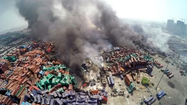 Ein Stapel brennender Container erzeugt dichten, schwarzen Rauch.