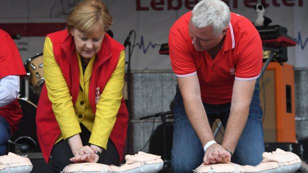 Auch die deutsche Bundeskanzlerin Angela Merkel übt die richtige Wiederbelebung nach Herzstillstand.