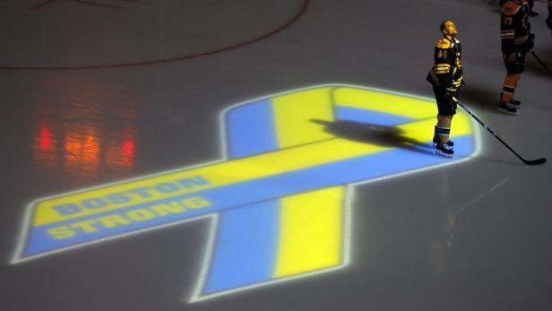 Boston Bruins Dennis Seidenberg observes a moment of silence for the victims of the Boston Marathon bombings before the start of an NHL hockey game against the Buffalo Sabres at TD Garden in Boston, Massachusetts April 17, 2013. This is the first sporting event to be held in Boston after the explosions that killed three and injured more than one hundred at the Boston Marathon. REUTERS/Jessica Rinaldi (UNITED STATES - Tags: SPORT ICE HOCKEY CRIME LAW)