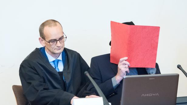 Der Angeklagte hinter einer Mappe vor Gericht