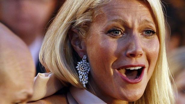 Gwyneth Paltrow mit blonden Haaren und auffälligen Ohrringen lächelt.