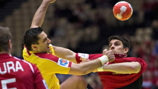 Zwei Handballspieler kämpfen um den Ball während eines Spiels.