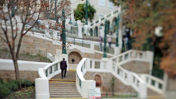 Ein Mann geht die Treppe im Burggarten in Wien hinauf.