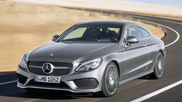 Ein graues Mercedes-Benz C-Klasse Coupé fährt auf einer kurvenreichen Straße.