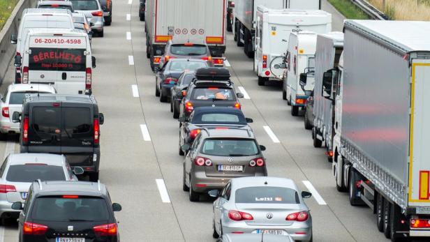 Stau auf einer Autobahn mit vielen Autos und Lastwagen.