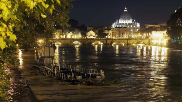Blick auf den Tiber in Rom mit dem Petersdom im Hintergrund bei Nacht.