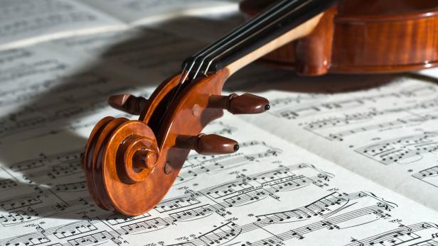 Nahaufnahme einer Geige auf einem Notenblatt.