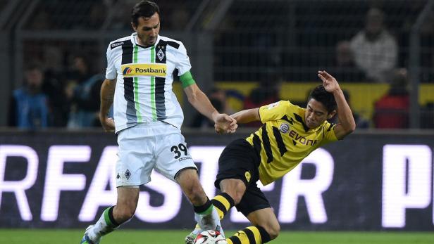 Zwei Fußballspieler kämpfen um den Ball während eines Bundesligaspiels.