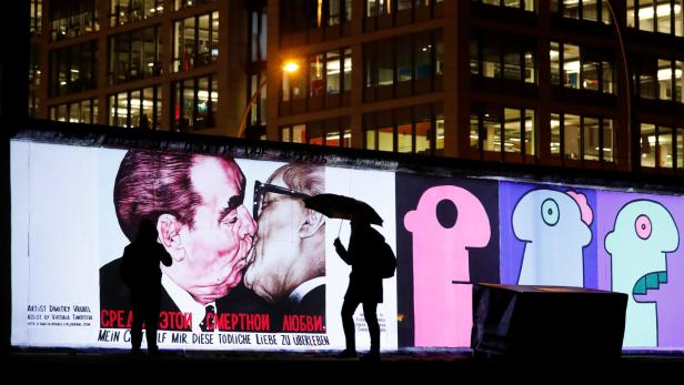 Projektion auf den größten verbliebenen Mauerrest in Berlin, berühmter &quot;Bruderkuss&quot; von Leonid Breschnew und Erich Honecker