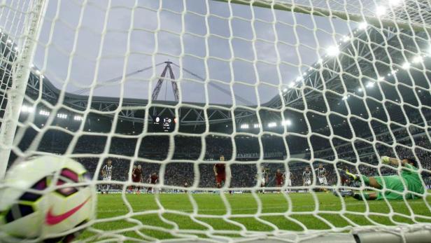 Blick durch das Tornetz auf ein Fußballspiel in einem Stadion.