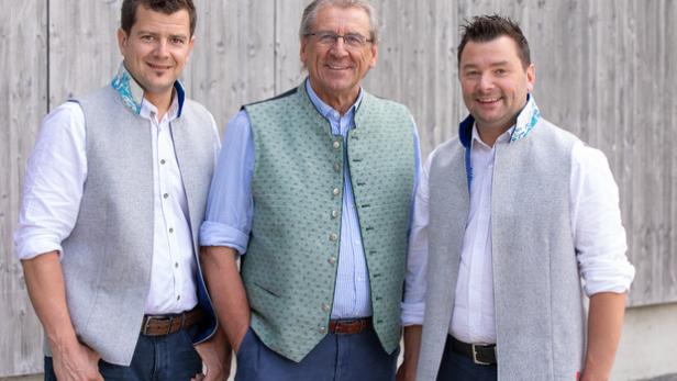 Im Bild: Heumilch-Pionier Heinz Kröll (Mitte) mit seinen Söhnen Heinrich (l.) und Christian (r.), die das Unternehmen in dritter Generation führen. / Fotograf: Christian Forcher