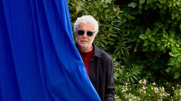 André Heller in seinem Refugium „Anima“: Blaue Vorhänge rahmen den Blick in den Garten ein