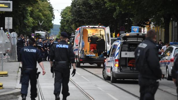 Polizeibeamte und ein Krankenwagen sind im Einsatz auf einer Straße.