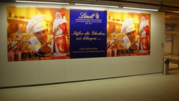 Eine Lindt-Weihnachtswerbung mit einem Koch und einer Schokoladen-Weihnachtsfigur.