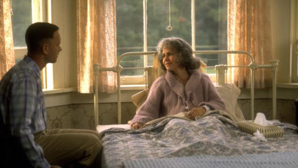 Forrest Gump sitzt am Bett seiner kranken Mutter.